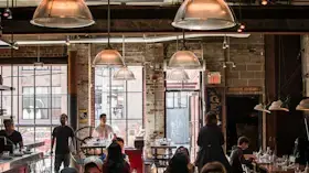 Restaurant interior with hanging lights and people seated